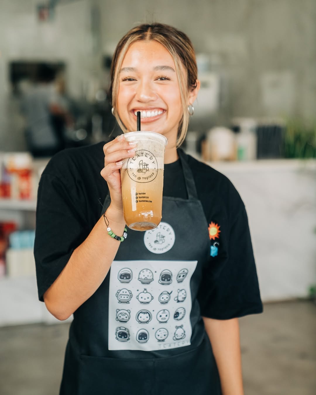 Teatery team member holding a handcrafted drink